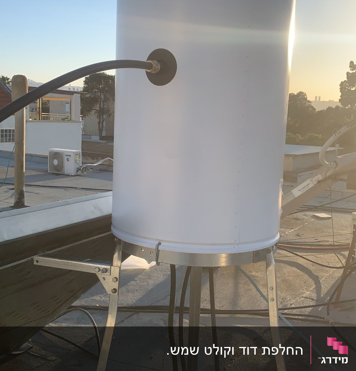 דוד שמש לבן על גג עם צינורות מחוברים